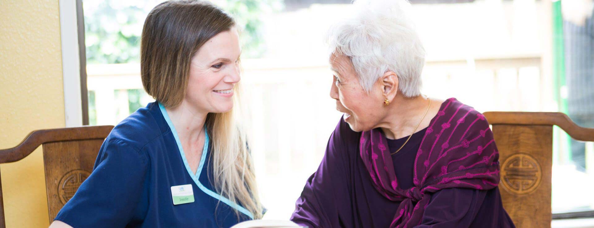 Caregiver talking with elderly woman