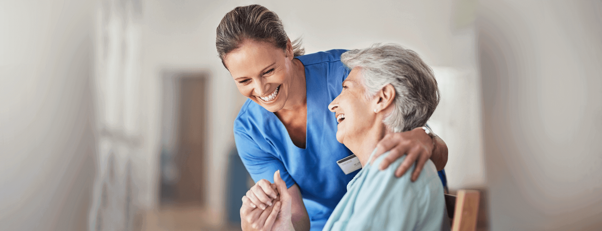 Caregiver and elderly woman laughing