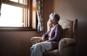 Elderly Woman Looks Out Window
