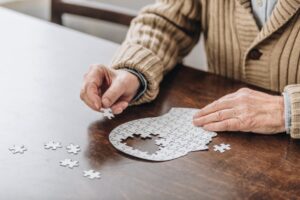 Dementia patient completing puzzle in shape of brain 